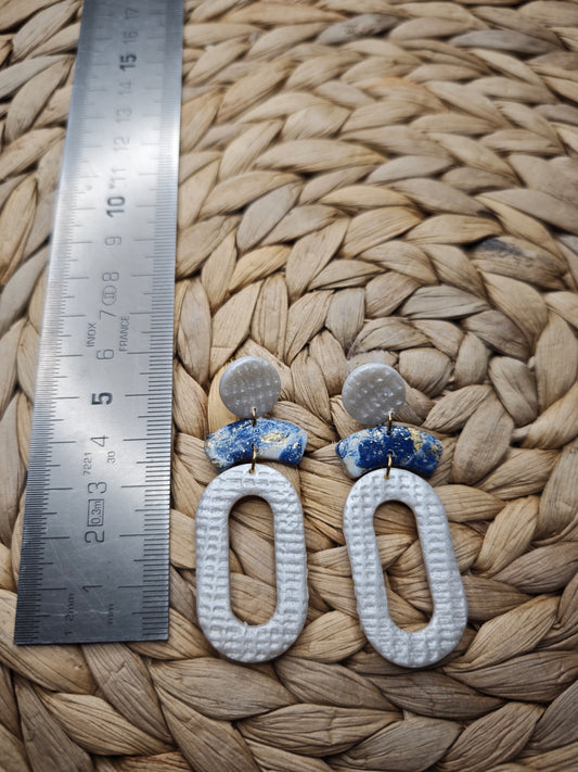 Zilverkleurige oorbellen met blauw detail en ovale hanger